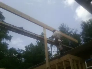 Carpenter setting a ridge beam over a new addition frame — Ice Dam Removal by Roofing Brothers in Pomona