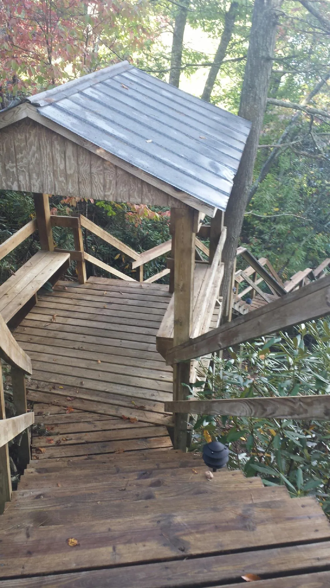 Metal roofed shelter over wooden steps on a wooded walkway — Skylight Repair & Installation work by our crew in Pomona