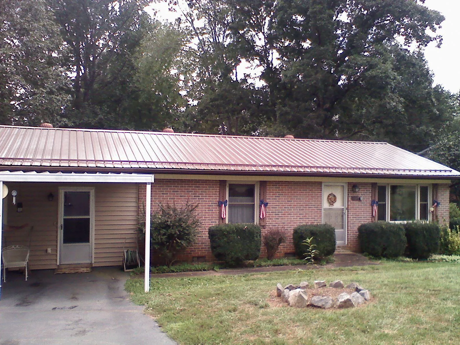 Bronze metal roof and carport on a brick ranch home — Roof Repair work by our crew in Pomona
